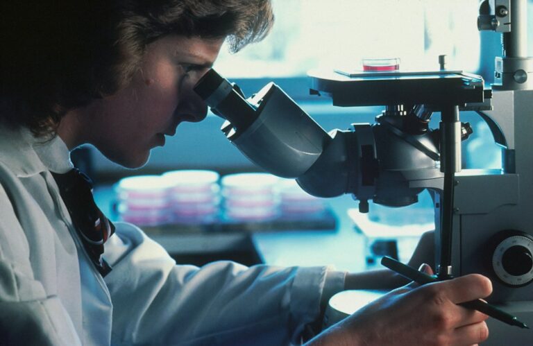 Científica trabajando en un microscopio en un laboratorio
